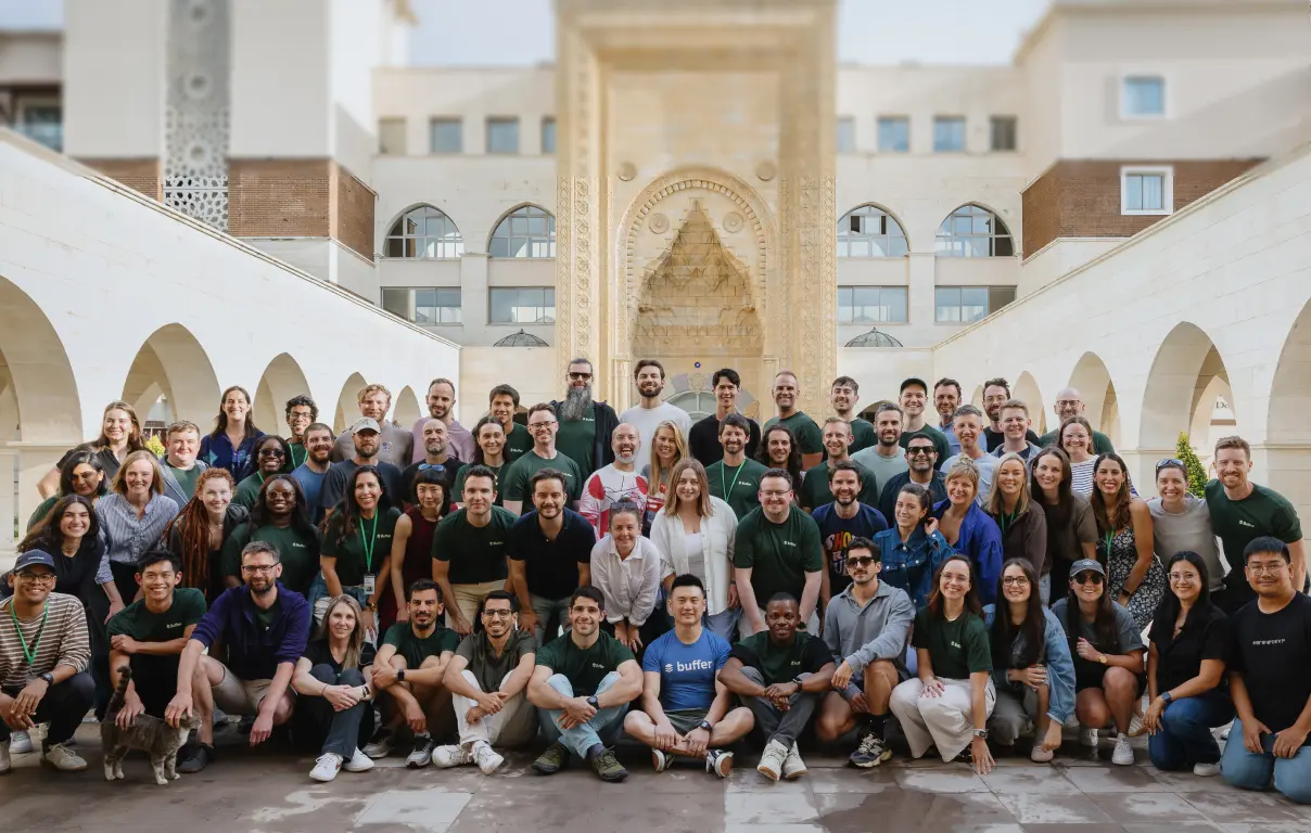 El equipo de Buffer reunido durante el retiro de 2025 en Turquía frente a un hotel con decoración tradicional de relieves tallados.